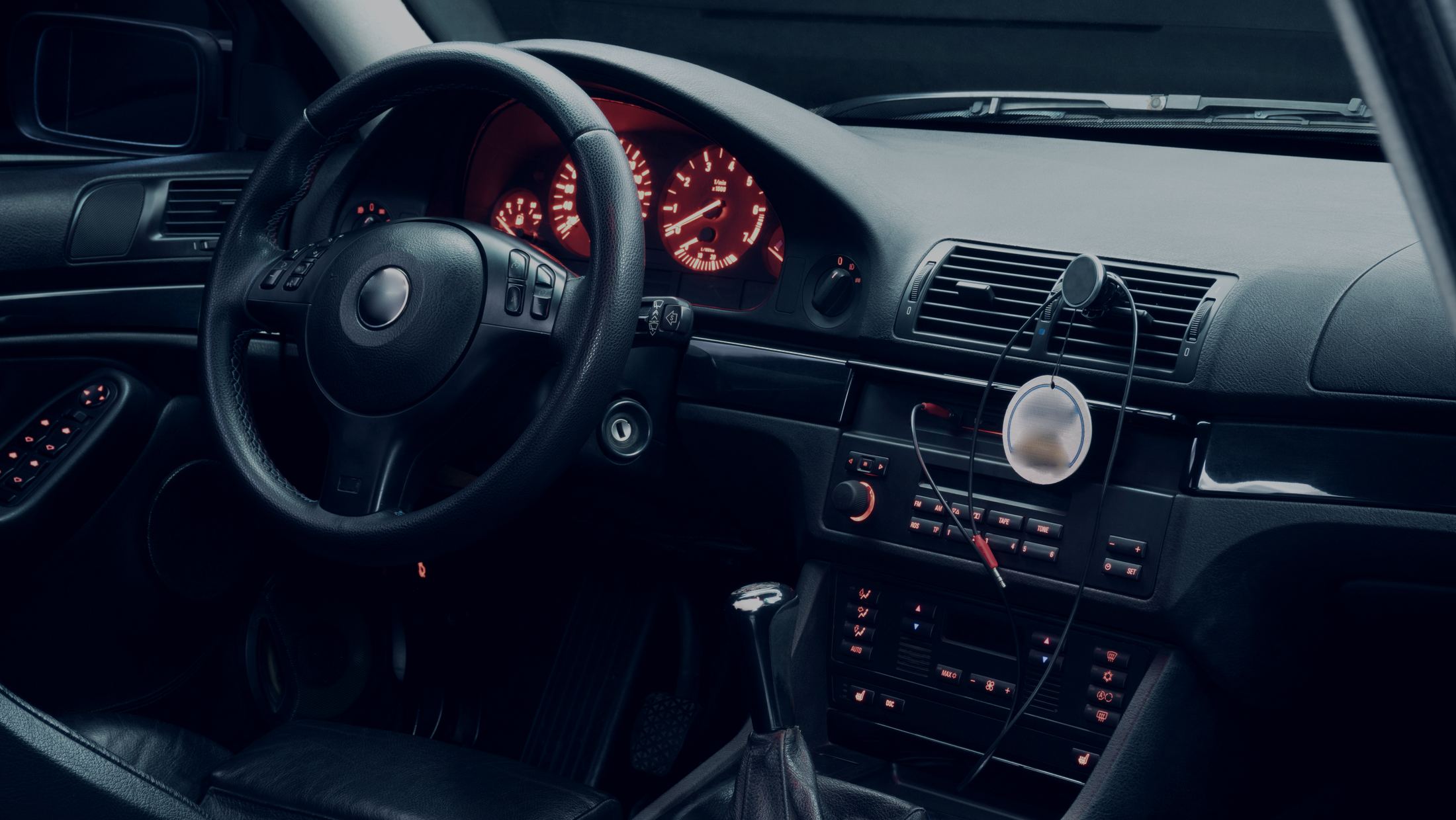 Dark car interior at night with the dash lit up