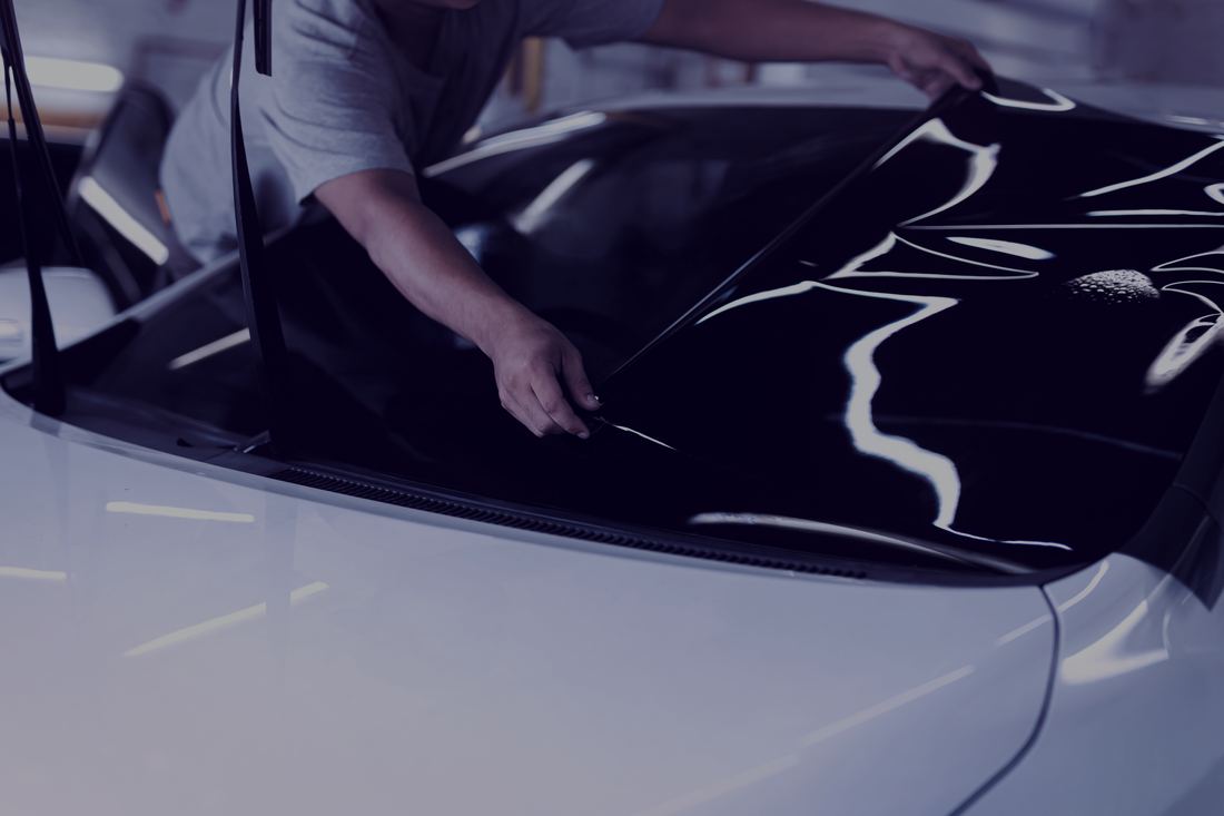 Installer applying tint film to a windshield